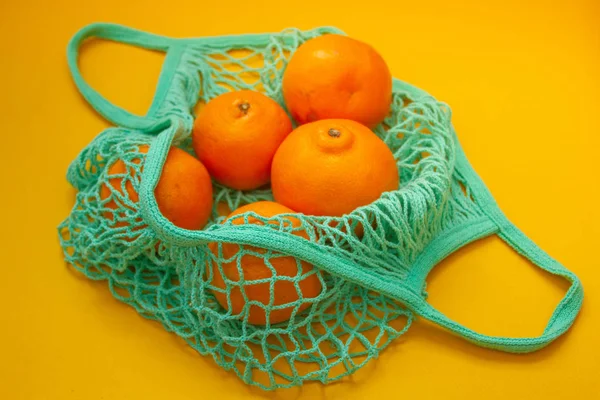 Tangeriner Och Apelsiner Ligger Neo Mint Sträng Väska Orange Bakgrund — Stockfoto