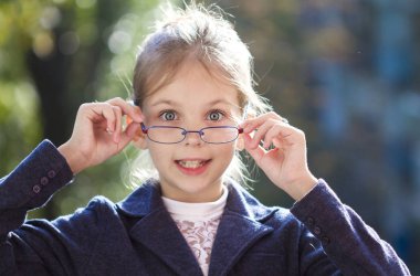 Gözlüklü şirin bir kızın portresi.