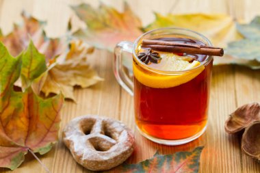 Portakal dilimli sıcak çay, ahşap masada anason ve tarçın..