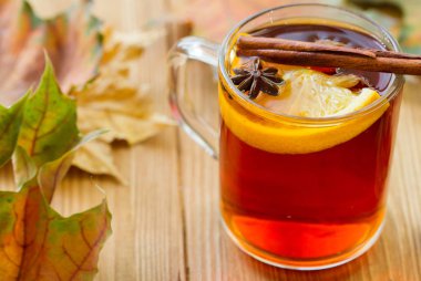 Portakal dilimli sıcak çay, ahşap masada anason ve tarçın..