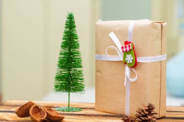 Noel hediyesi kutusunda köknar ağacı ve ahşap masa.