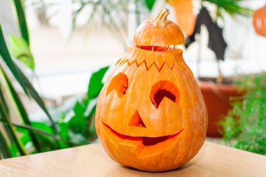 Cadılar bayramında parlak, korkunç balkabağı. Masada bal kabağı var. Sonbahar geleneği.