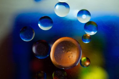 Aydınlatılmış cam yüzeyinde su damlaları olan soyut duvar kağıdı