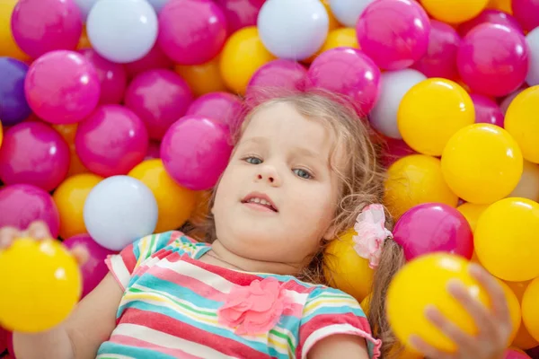 可爱的小女孩穿着鲜艳的塑料球玩耍 是孩子们的闲暇 — 图库照片