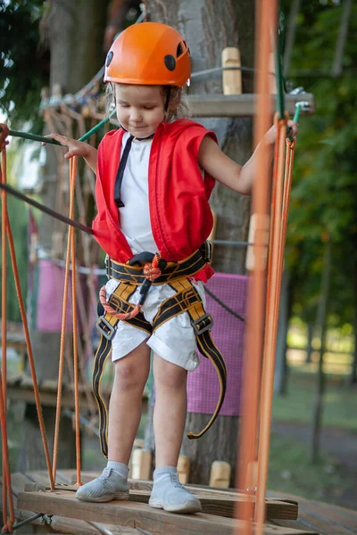 Uma Menina Capacete Laranja Proteção Especial Passa Por Obstáculos Parque — Fotografia de Stock