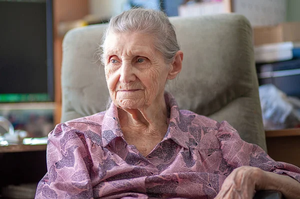 Starsza Kobieta Różowej Bluzce Siedzi Domu Krześle Babcia Się Uśmiecha — Zdjęcie stockowe