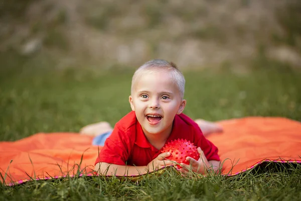 Een Jongen Met Syndroom Ligt Het Park Een Oranje Tapijt — Stockfoto