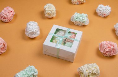 Elma ve nane şekerinden yapılmış ev yapımı marşmelov tabağıyla düz uzanan lokum, turuncu bir kağıdın arka planındaki bir kutuda uzanıyor..