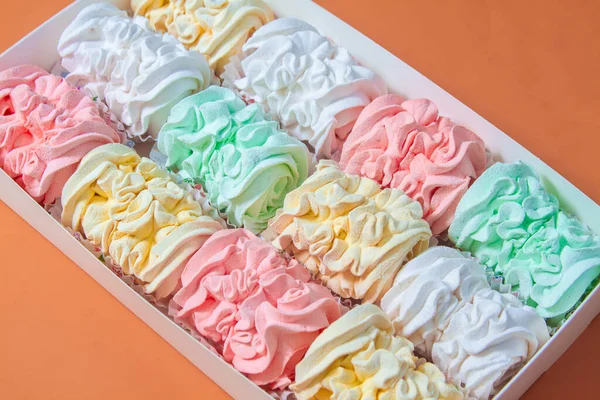 Elma ve nane şekerinden yapılmış ev yapımı marşmelov tabağıyla düz uzanan lokum, turuncu bir kağıdın arka planındaki bir kutuda uzanıyor..