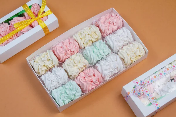 Elma ve nane şekerinden yapılmış ev yapımı marşmelov tabağıyla düz uzanan lokum, turuncu bir kağıdın arka planındaki bir kutuda uzanıyor..