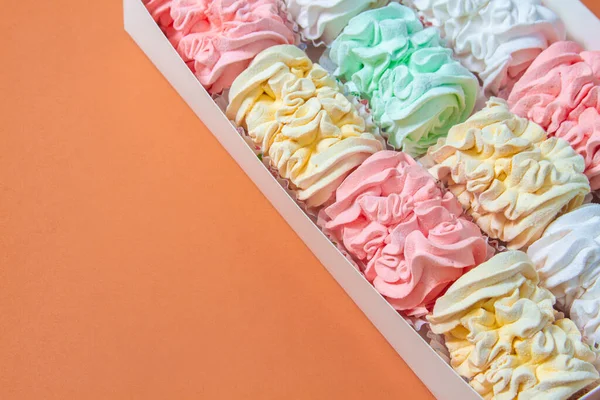 Elma ve nane şekerinden yapılmış ev yapımı marşmelov tabağıyla düz uzanan lokum, turuncu bir kağıdın arka planındaki bir kutuda uzanıyor..