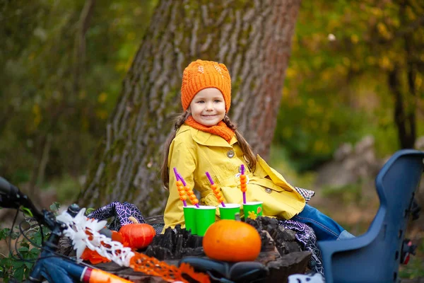 公園に座って カボチャを手に持っている小さなかわいい女の子 ハロウィーンのコンセプト 秋の風景 — ストック写真