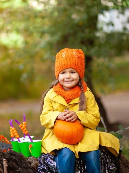 公園に座って カボチャを手に持っている小さなかわいい女の子 ハロウィーンのコンセプト 秋の風景 — ストック写真