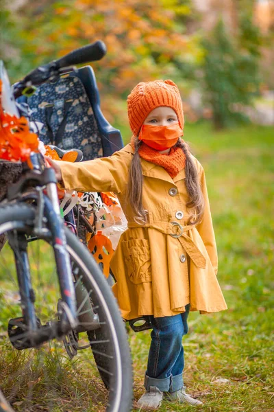 Malá Roztomilá Dívka Ochranné Masce Obličeje Oranžový Klobouk Dítě Stojí — Stock fotografie