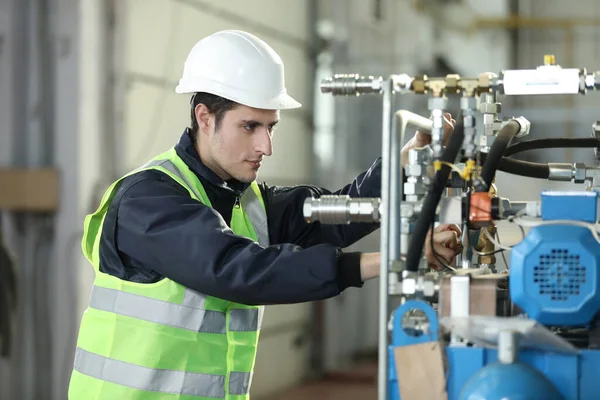 Bir adamın portresi, fabrika mühendisi iş kıyafetleri içinde uçak üreticisinin çalışma sürecini kontrol ediyor..