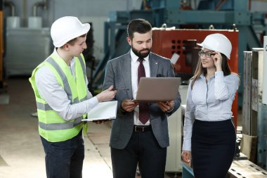 Sağlam bir işadamının portresi. Elinde tablet olan sekreteri ve fabrika mühendisi. Bir uçak fabrikasındaki fabrika mali raporundan bahsediyor.