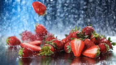 Düşen çilekler, suyun altında koyu mavi bir zemin üzerine düşer. Sağlıklı bir yaşam tarzı. Multivitamin kokteyli. Yaz diyeti. Suyun altında meyve seti. Düşen çilekler. Hareket fotoğrafçılığı