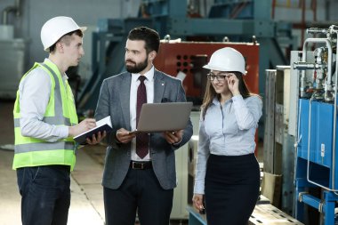 Sağlam bir işadamının portresi. Elinde tablet olan sekreteri ve fabrika mühendisi. Bir uçak fabrikasındaki fabrika mali raporundan bahsediyor.