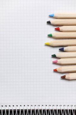 Beyaz defterin düz görünümü, masa üzerindeki renkli kalemler. Bir okul için hazırlanıyorum. Okula geri dön..