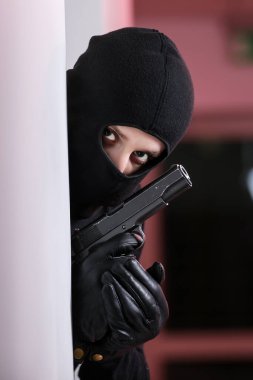 Siyah ceketli ve siyah maskeli bir adam tarafından yapılan ev soygunu. Maskeli bir hırsız. Maskeli bir hırsız başkalarının evine girmeye çalışıyor.