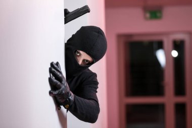 Siyah ceketli ve siyah maskeli bir adam tarafından yapılan ev soygunu. Maskeli bir hırsız. Maskeli bir hırsız başkalarının evine girmeye çalışıyor.