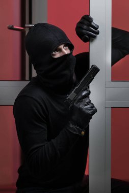 Hırsız daireye girmiş. Siyah ceketli ve siyah maskeli bir adam tarafından yapılan ev soygunu. Maskeli bir hırsız. Maskeli bir hırsız başkalarının evine girmeye çalışıyor.
