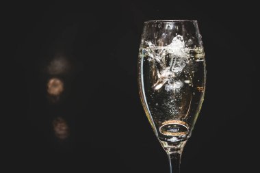 Şampanya bardağına bir çift alyans düştü. Şampanya sıçrıyor. Düğün günü. Mutlu çift.