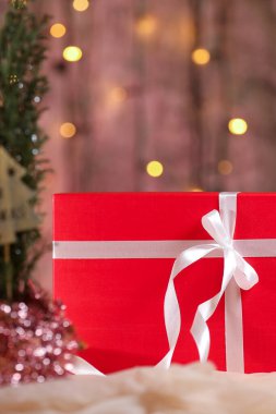 Masasında beyaz kurdele olan kırmızı Noel hediyesi kutusu.. 