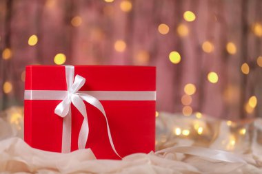 Masasında beyaz kurdele olan kırmızı Noel hediyesi kutusu.. 