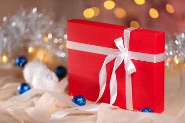 Masasında beyaz kurdele olan kırmızı Noel hediyesi kutusu.. 