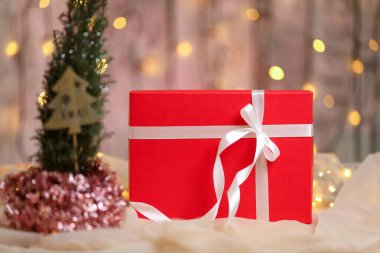 Masasında beyaz kurdele olan kırmızı Noel hediyesi kutusu.. 