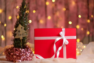 Masasında beyaz kurdele olan kırmızı Noel hediyesi kutusu.. 