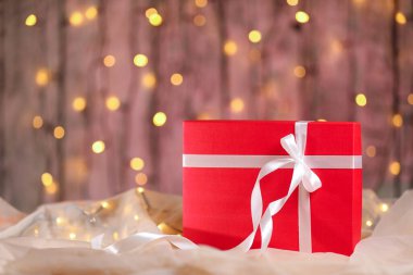 Masasında beyaz kurdele olan kırmızı Noel hediyesi kutusu.. 