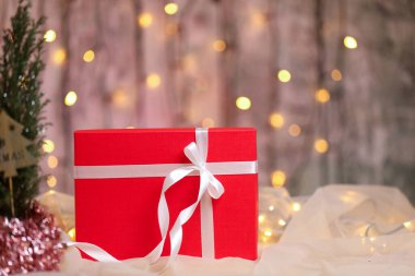 Masasında beyaz kurdele olan kırmızı Noel hediyesi kutusu.. 
