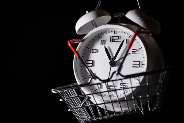 Red shopping basket with white retro alarm clock in it. Lose time. Buy time. Break. Motivation. Business solutions. Success. Deadline.