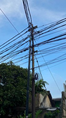 Network of electric cables on electric poles with a cloudy sky in the day with lamp