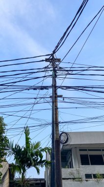 Network of electric cables on electric poles with a cloudy sky in the day with lamp