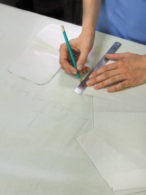 Küçük bir aile terzi desen üzerinde çalışan bir kadın.