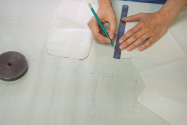 Küçük bir aile terzi desen üzerinde çalışan bir kadın.