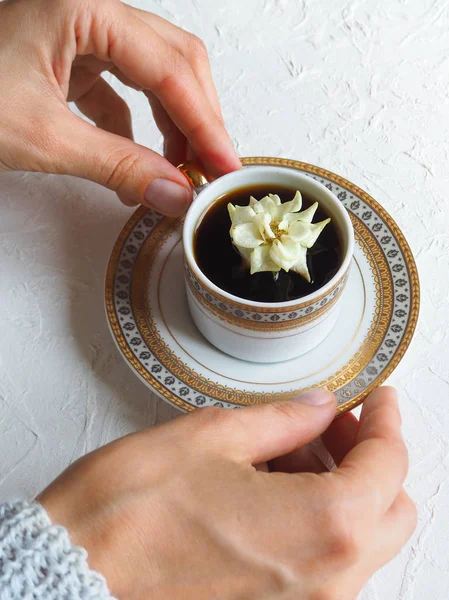 De bloem in de cup. Een beetje wit steeg in een kopje zwarte koffie. Het concept van comfort en schoonheid. — Stockfoto