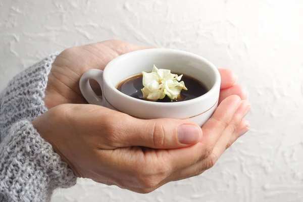 Een beetje wit steeg in een kopje zwarte koffie. Het concept van comfort en schoonheid. De bloem in de beker. — Stockfoto