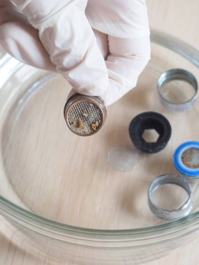 Ev temizleme solüsyonu kullanarak vincin filtre üzerinde kireç temizleme. Sirke gravür kireç.