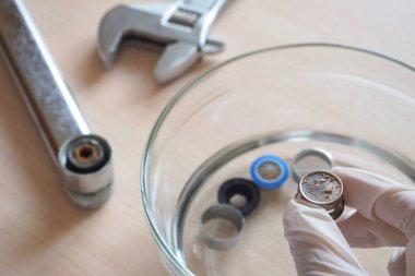 Ev temizleme solüsyonu kullanarak vincin filtre üzerinde kireç temizleme. Sirke gravür kireç.