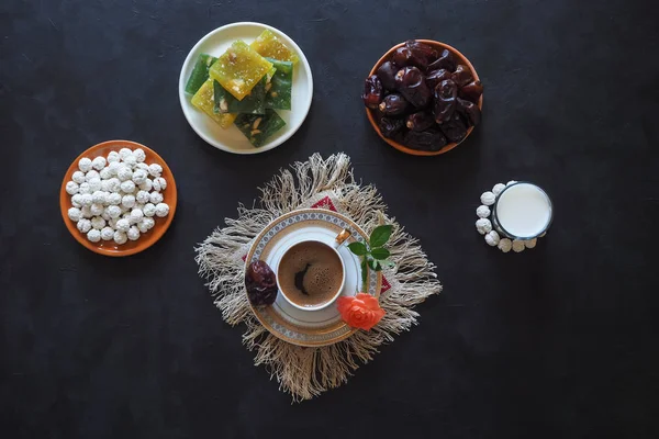 Черный кофе и даты на черном столе. Сладкая еда для Рамадана . — стоковое фото