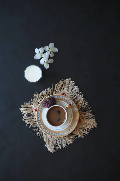 Zwarte koffie en een glas melk op de zwarte lijst. Het concept van Ramadan voedsel. — Stockfoto