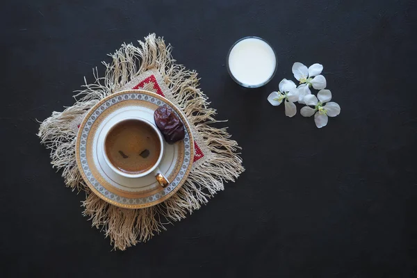 Zwarte koffie en een glas melk op de zwarte lijst. Het concept van Ramadan voedsel. — Stockfoto