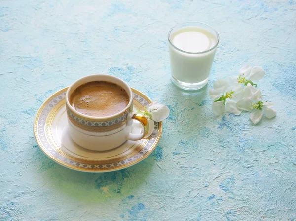 Zwarte koffie en een glas melk op een turkooizen achtergrond. Ramadan voedsel. — Stockfoto