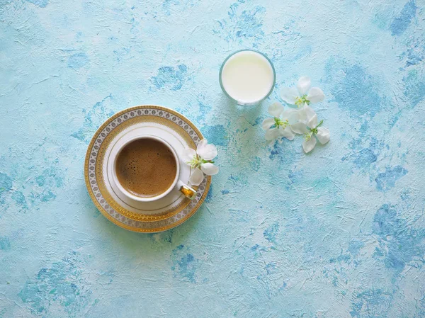Zwarte koffie en een glas melk op een turkooizen achtergrond. Ramadan voedsel. — Stockfoto