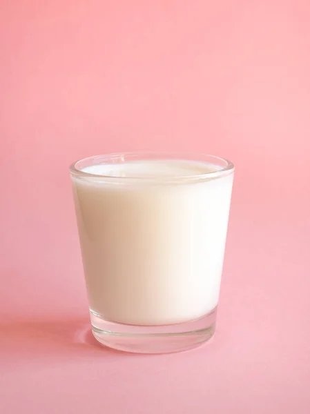 Ein Glas frische Milch auf rosa Hintergrund. — Stockfoto