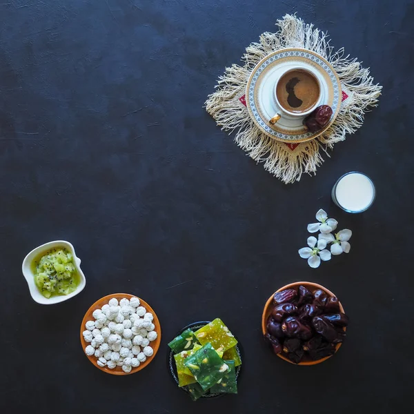 Schwarzer Kaffee, Milch, Datteln und türkische Süßigkeiten auf schwarzem Hintergrund. Süßes für Ramadan — Stockfoto